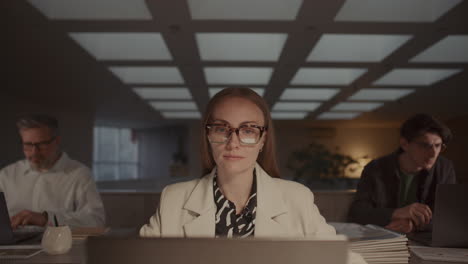 confident businesswoman working on laptop at desk in modern office space