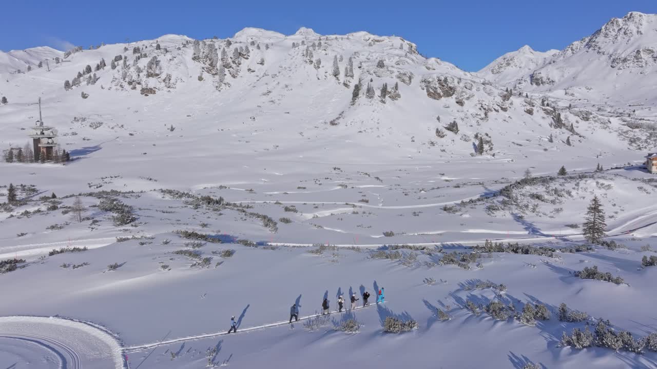 Outdoor group gliding over fresh snow with snowshoes in Obertauern