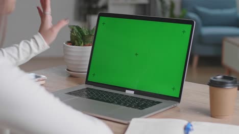 close up hands girl waving during video call on laptop computer with green screen display at home, video in 4k