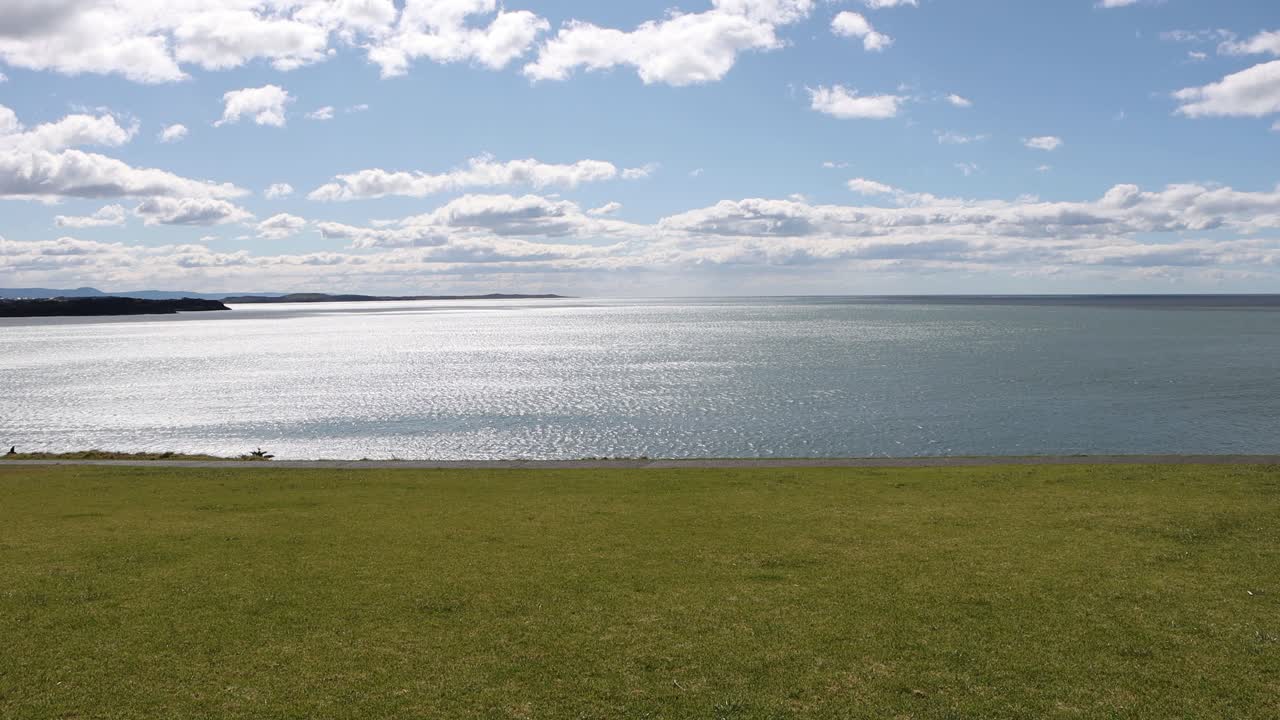 흐린 화창한 날 호주 뉴 사우스 웨일즈에 있는 키아마 해변의 풀이 무성한 해안, 잠긴 샷