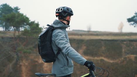 Männlicher-Radfahrer-Ruht-Trinkwasser-Mit-Einem-Mountainbike-Auf-Dem-Land