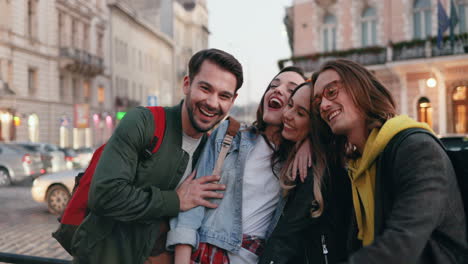 caucasian group of friends together in the street and smiling at the camera