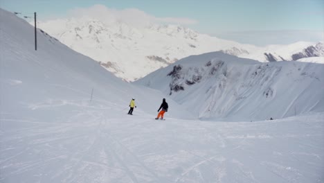 Skiing-down-the-slope-in-slow-motion-with-mountain-panorama-during-winter