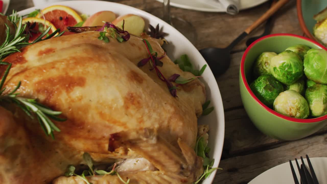 video de bandeja con pavo asado y diversos platos en superficie de madera