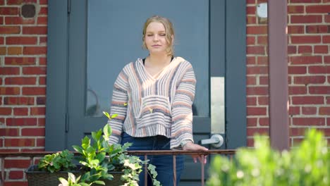 Girl-standing-against-rail-outside-of-a-school-door