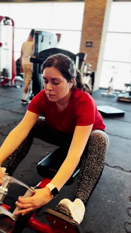 young woman performing seated cable rows exercise at the gym