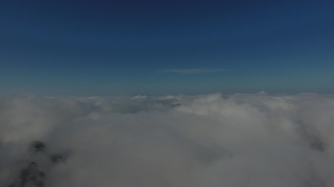 volando sobre las altas montañas en hermosas nubes. vista aérea.