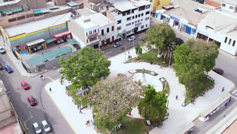 amazing drone shot over the famous "plazuela de elías aguirre" park in the city of chiclayo, peru during a cloudy day with cars passing by