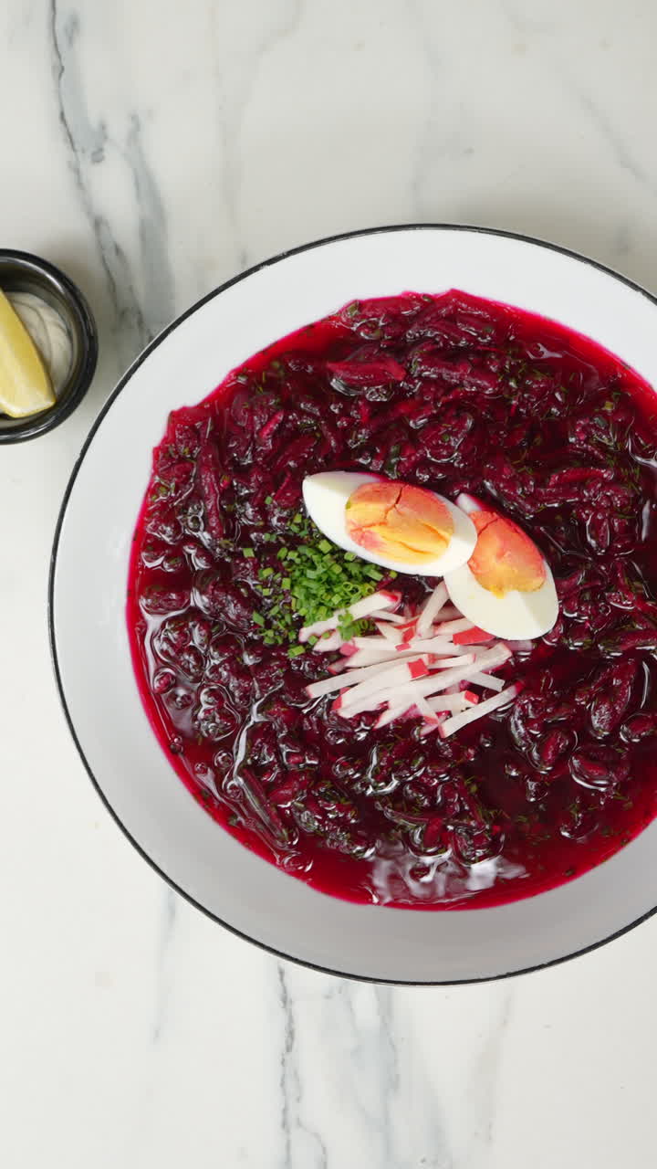Vertical footage Traditional Ukrainian borscht soup, a vibrant beet based dish garnished with boiled egg, fresh radish, and chives, presented in various close up shots