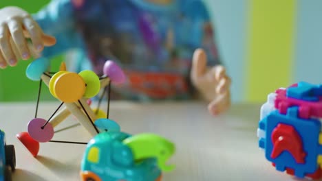 boy sitting next to toy. kid boy playing with toys indoors