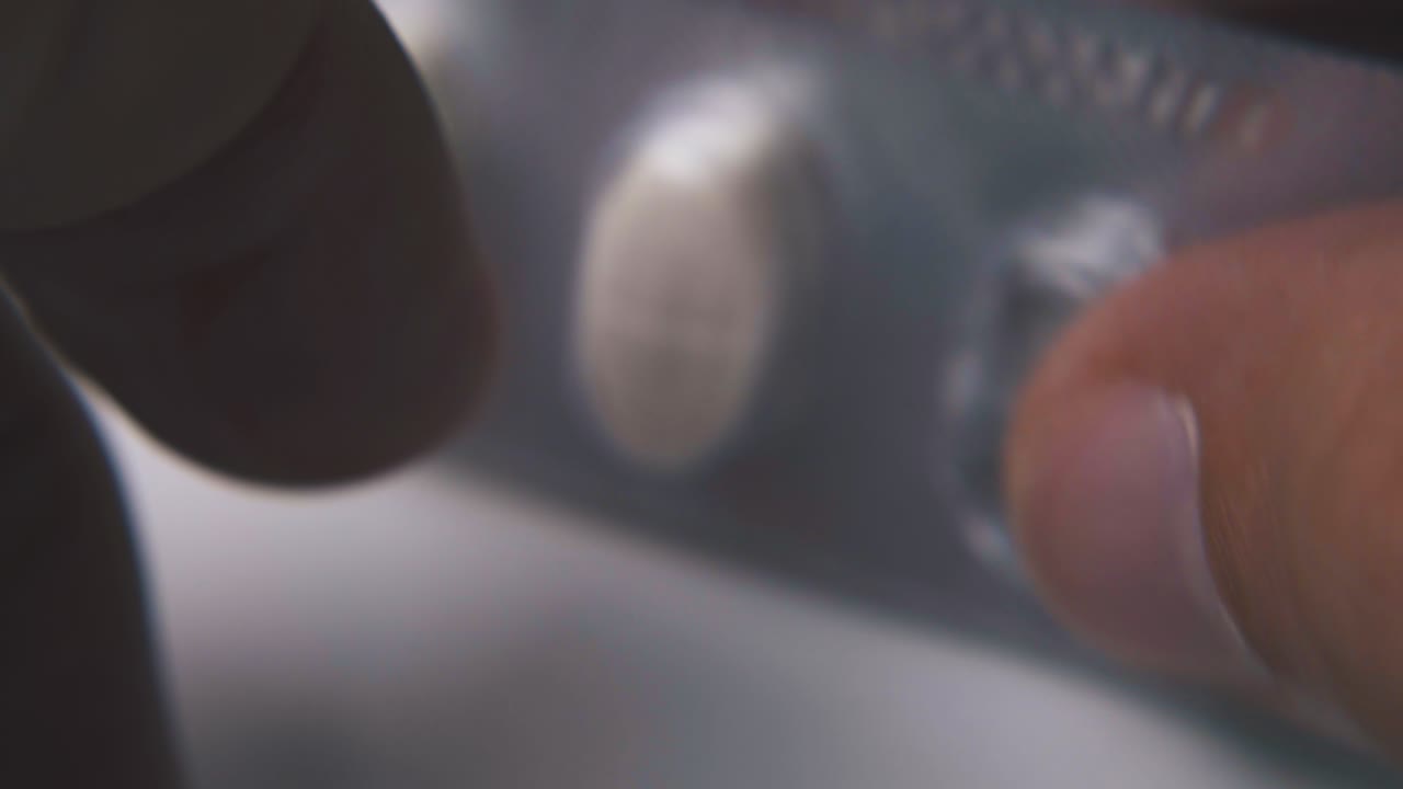 persona golpea con los dedos las pastillas ampollas en una superficie clara