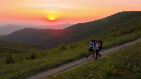 hikers on a mountain trail at sunset