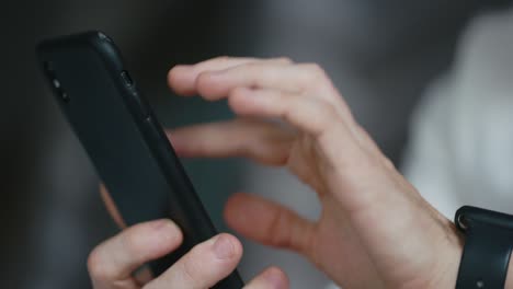 close-up of male hands using smartphone