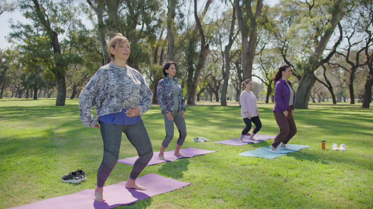 mujeres practicando yoga en un parque