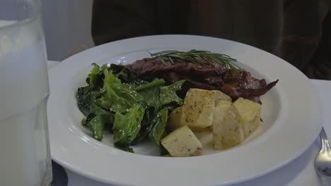 ternera a la parrilla con espinacas y patatas toscana en un restaurante italiano