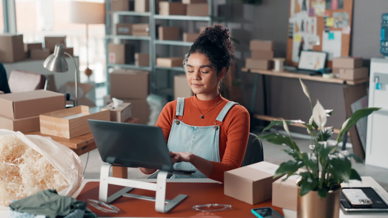 Woman working on laptop surrounded by boxes