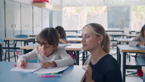 maestra de escuela primaria ayudando a colegiala latina