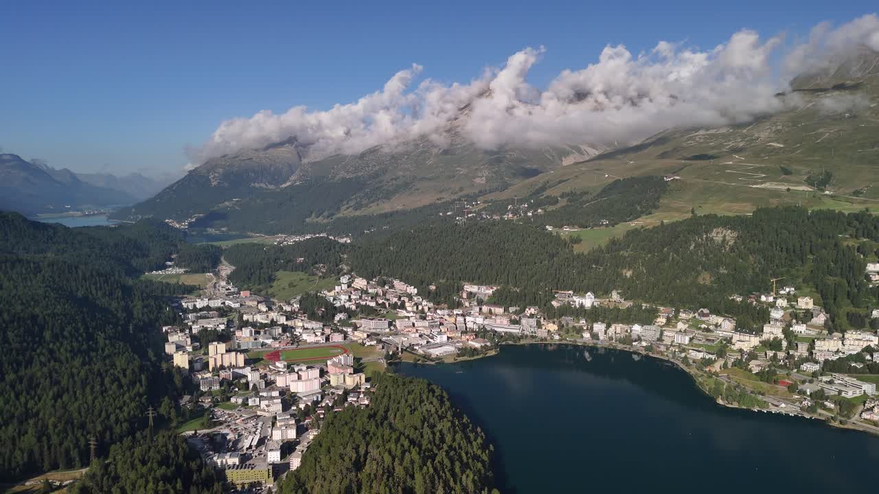 Backward shot of beautiful view of Lake St. Moritzersee and the city of St. Moritz, Switzerland. Drone view.