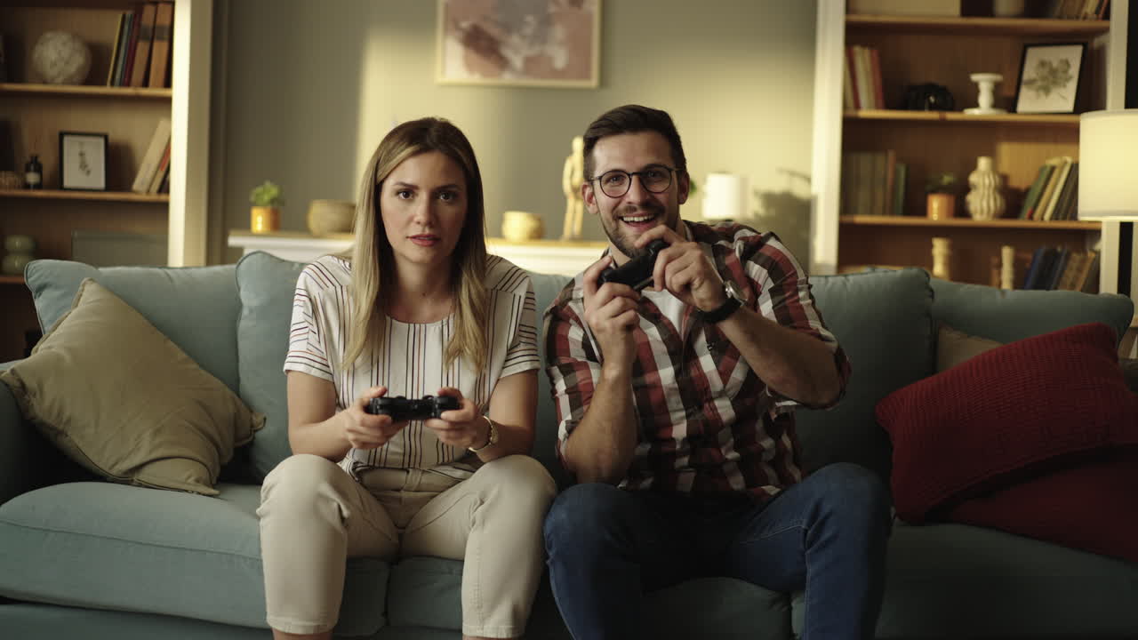 Coppia che gioca ai videogiochi sul divano