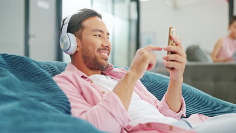 headphones, phone and business man on sofa