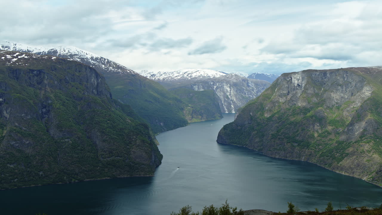 Zeitrafferaufnahme eines Fjords in der Nähe von Aurland in Norwegen. Wolken ziehen schnell über die Landschaft. Die Schatten der Wolken sind auf den steilen Bergen zu sehen.