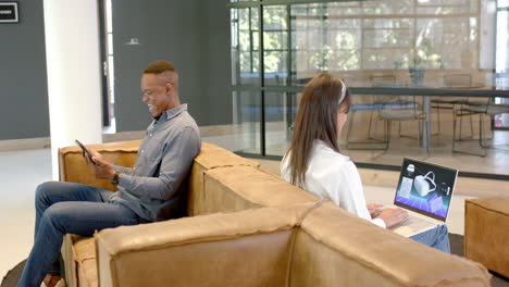 working on laptop and tablet, business colleagues collaborating in modern office