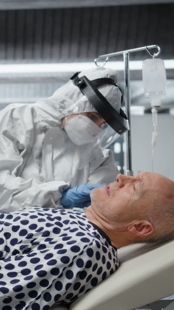 Vertical Video Doctors team in hazmat suits examining patient with infection symptoms