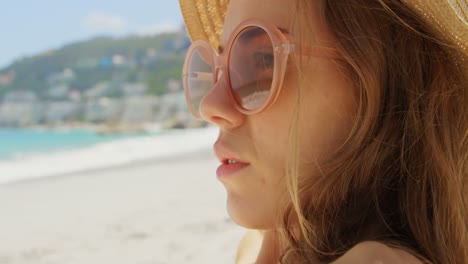 Side-view-of-Caucasian-woman-in-hat-relaxing-on-the-beach-4k