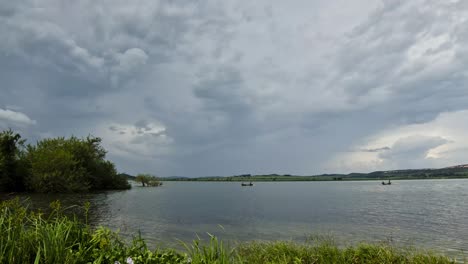 Un-Lapso-De-Tiempo-De-Barcos-Tradicionales-Pescando-En-El-Lago-Victoria-En-áfrica-Mientras-Las-Nubes-De-Tormenta-Llegan