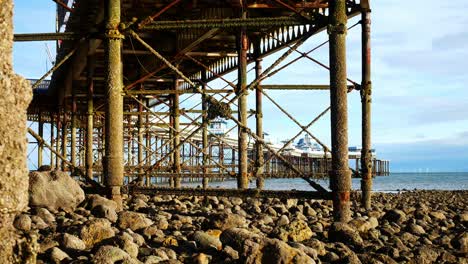 under weathered worn llandudno pier landmark support pillars at low tide