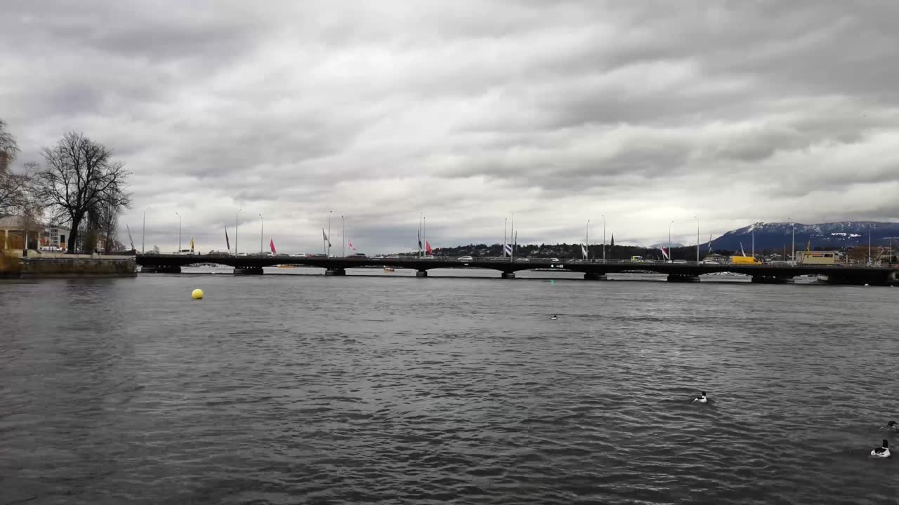 변덕스러운 하늘이 제네바 호수와 스위스 제네바에 있는 몽블랑 다리의 이 장면을 장식합니다.