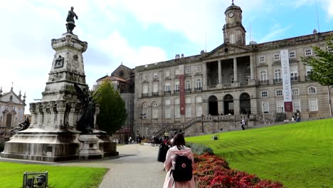 woman walks through infante dom henrique square towards palacio da bolsa