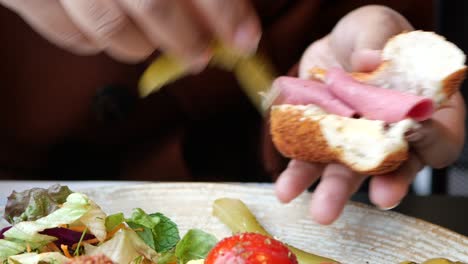 person eating a turkish breakfast sandwich