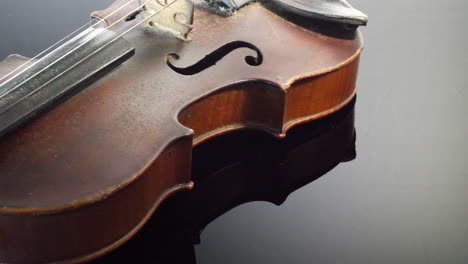 un instrumento de violín antiguo y caro que descansa sobre un piano de cola negro brillante en una orquesta sinfónica