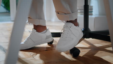 businessman legs sitting chair closeup. modern freelancer dancing feet working