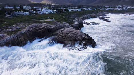 High-angle-view-of-wave-surging-in-and-smashing-dramatically-into-rocks-on-shore