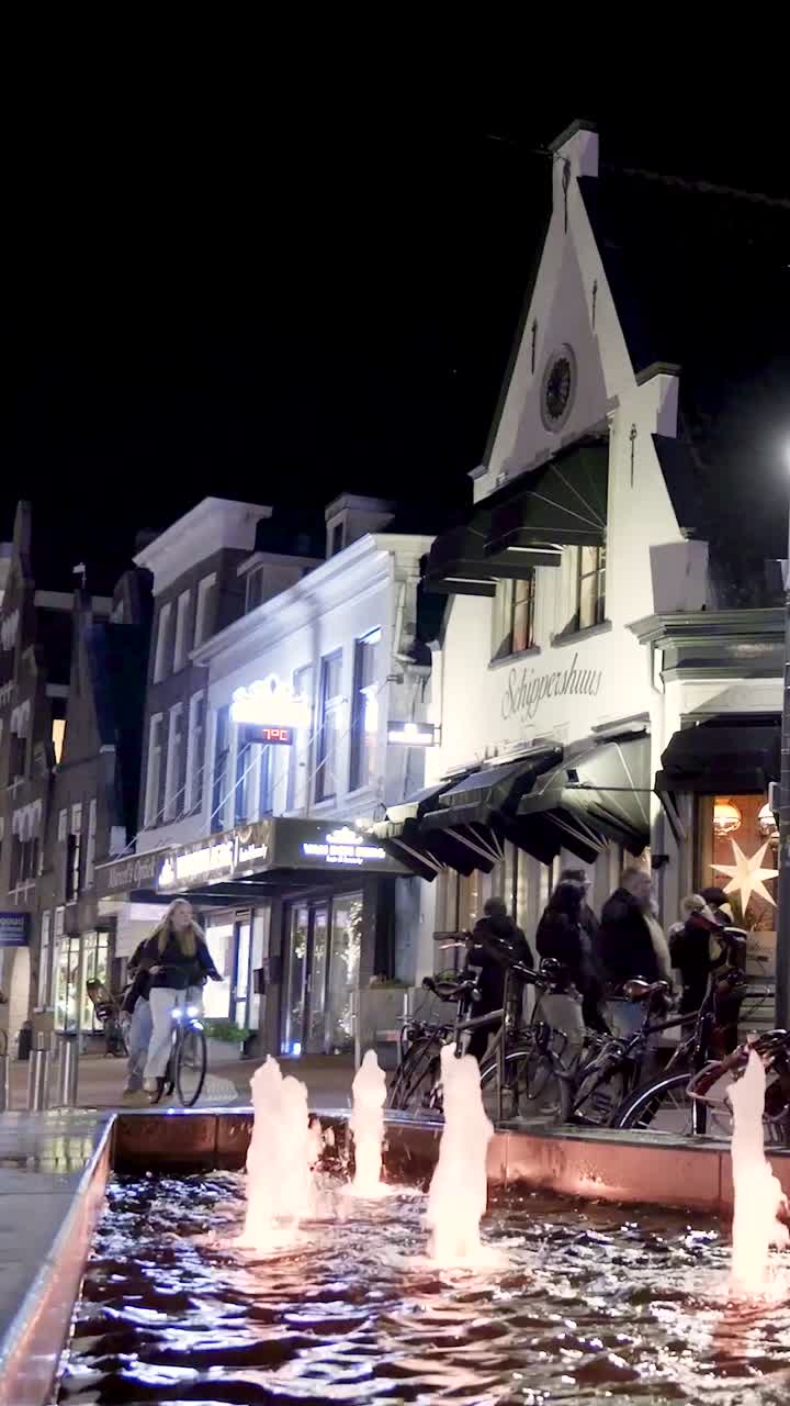 City street at night with fountain and people