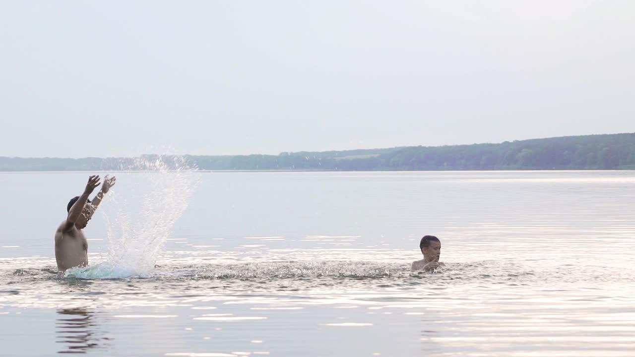 Jumping in the water. Man and boy are having fun and splashing in the water. Summer holiday concept