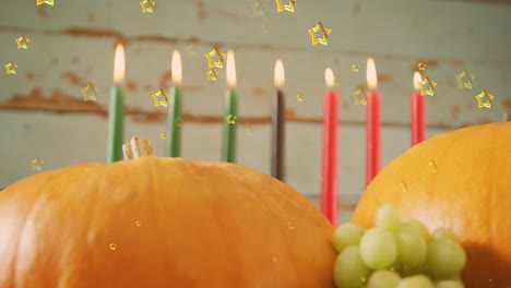 animation of golden stars over kwanzaa candles and pumpkins