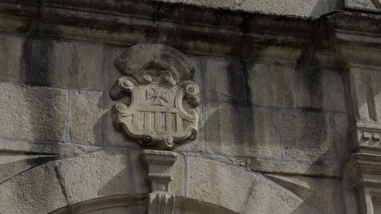 Vecchi archi di porta in pietra consumati dalle intemperie con uno stemma intagliato in cima