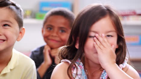 elementary school pupils listen and laugh in class, close up