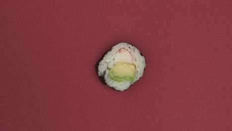 sushi roll rotating on red background