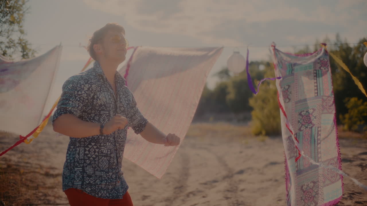 미소 짓는 젊은 남자가 해변에서 음악을 즐기고 있습니다.