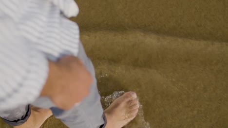 Primer-Plano-De-Alto-ángulo-De-Un-Hombre-Con-Camisa-Caminando-En-Agua-De-Mar.