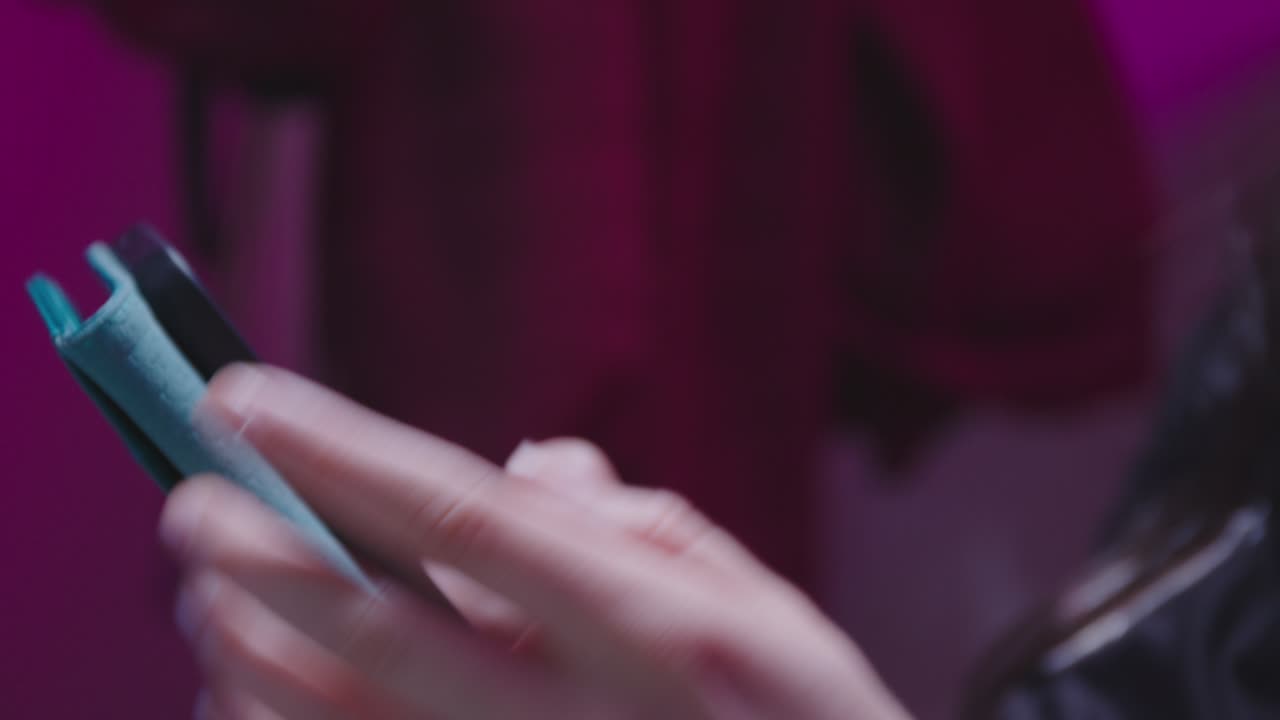 A cinematic close-up of a young woman relaxing with her eyes closed while listening to headphones, then scrolling on her smartphone