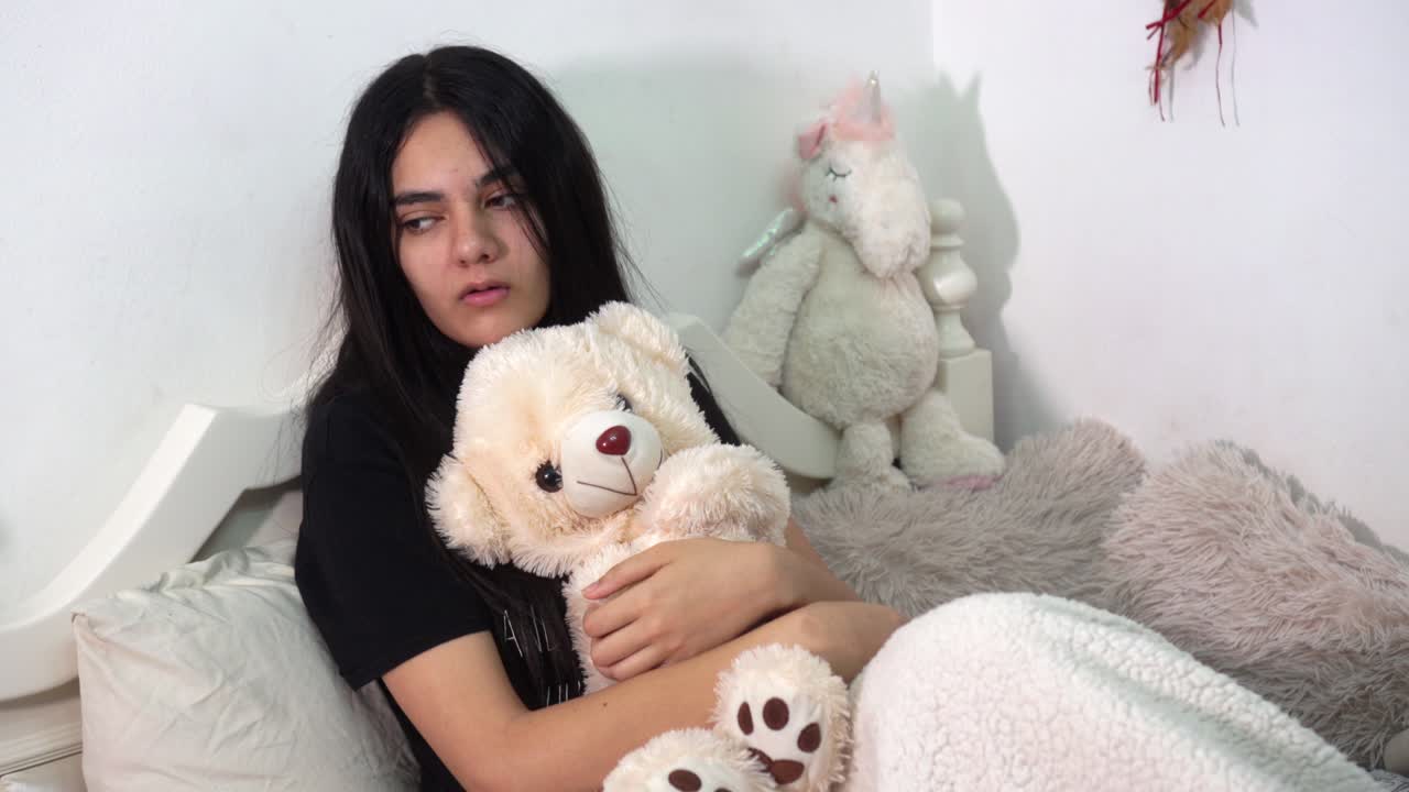 una chica deprimida lanza su oso de peluche