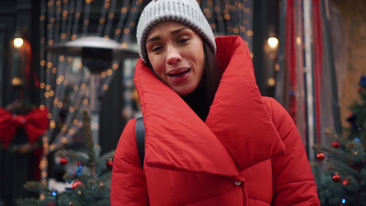 Woman in red jacket with Christmas lights