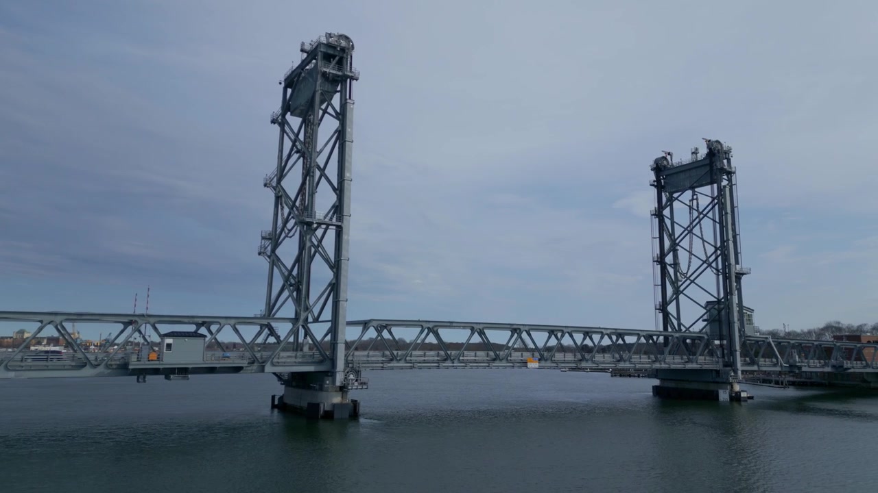 Aerial pan across Portsmouth Memorial bridge and serene waterways during daytime in New Hampshire