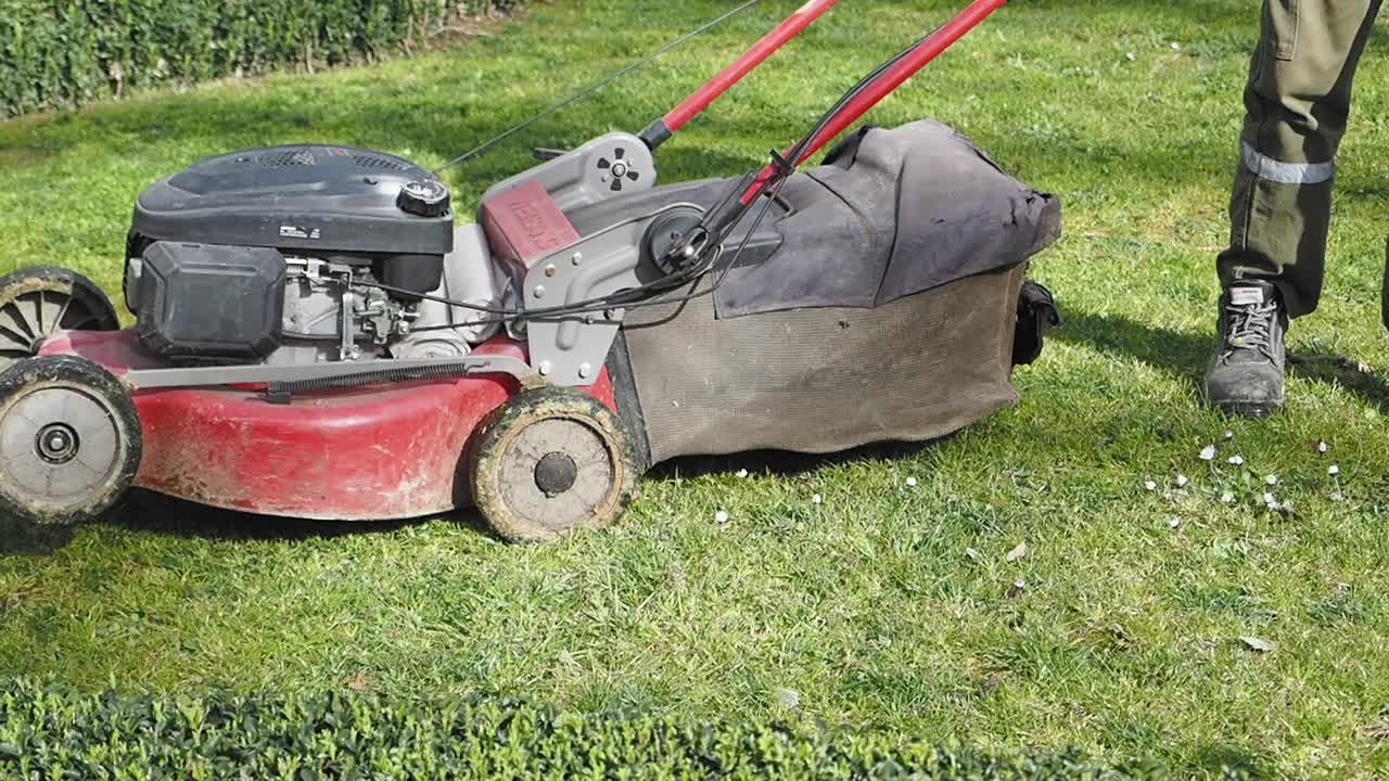 Person mowing the lawn with a lawn mower