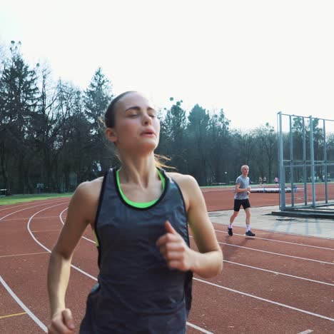 close-up of athletic woman working out and running on urban stadium running track. healthy lifestyle